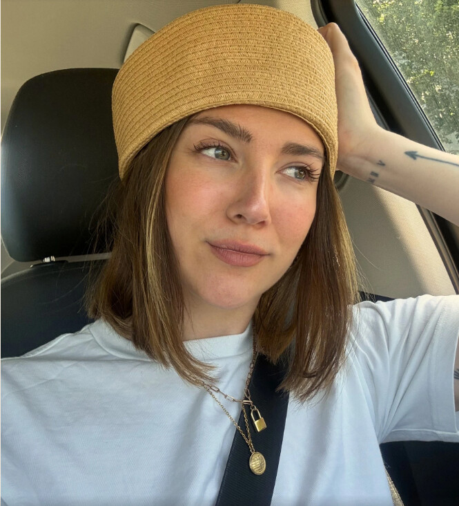 Manon en selfie voiture, chapeau de paille et t-shirt blanc, collier doré
