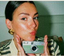 Manon en selfie avec un appareil photo argentique vert menthe