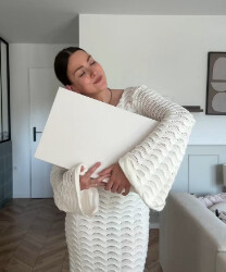 Manon tenant un ordinateur portable, robe en crochet blanc